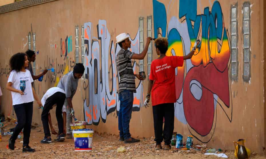 Young Sudanese paint elaborate graffiti on a wall in the Khartoum neighbourhood of Arkawit last year.
