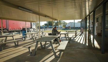 Black sits at a table outside the roadhouse