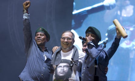 Rodrigo Londoño, AKA Timochenko, the top leader of the Farc, is embraced by singers of the Southern Rebels guerrilla band during the concert.