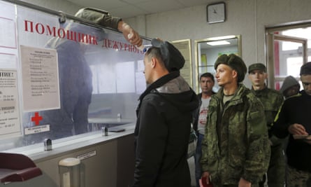 A Russian officer checks the temperature of recruits at a military recruitment centre in Volgograd