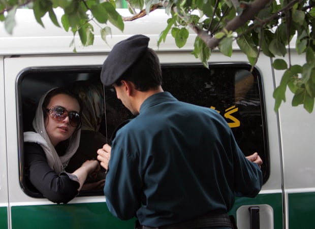 An Iranian police officer talks to a woman in Tehran.