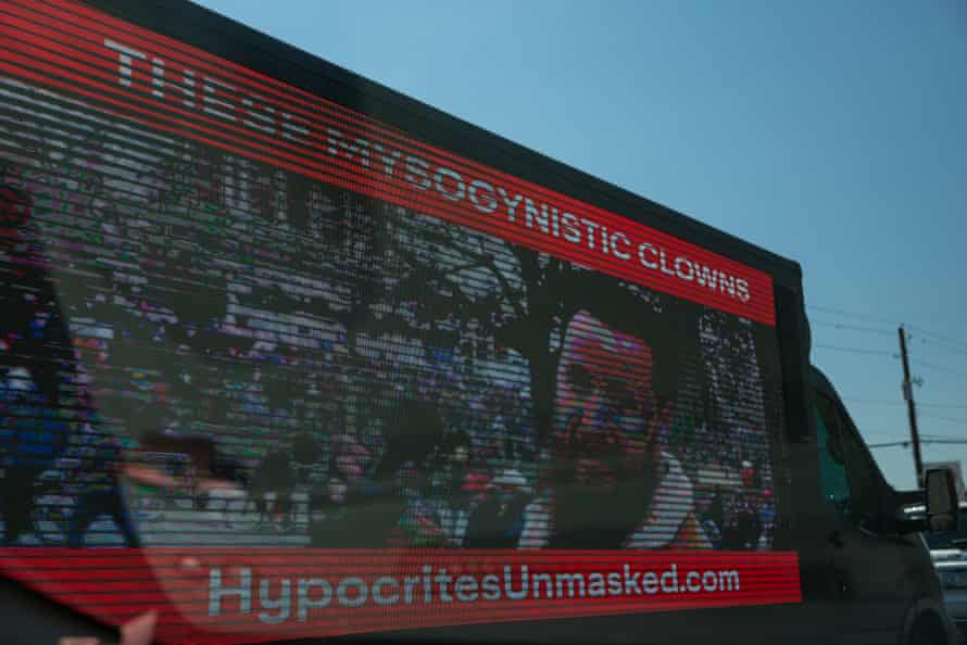 image on side of truck says "these mysogynist clowns - hypocrites unmasked dot com"