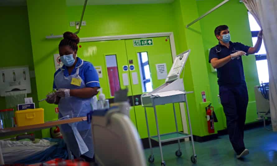A nurse, wearing a protective face mask and gloves, prepares medication for a patient at the Royal Blackburn teaching hospital