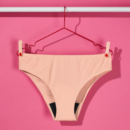 A pair of Bodyform ComfortFit Essentials Brazilian Light period pants on a red hanger against a pink background.