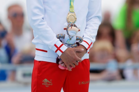 Alex Yee of Team England stands on the podium with his medal and mascot after winning gold in the men’s individual sprint triathlon final.
