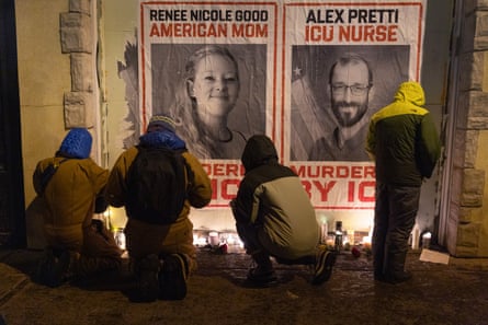 People kneel at a candlelight vigil outdoors