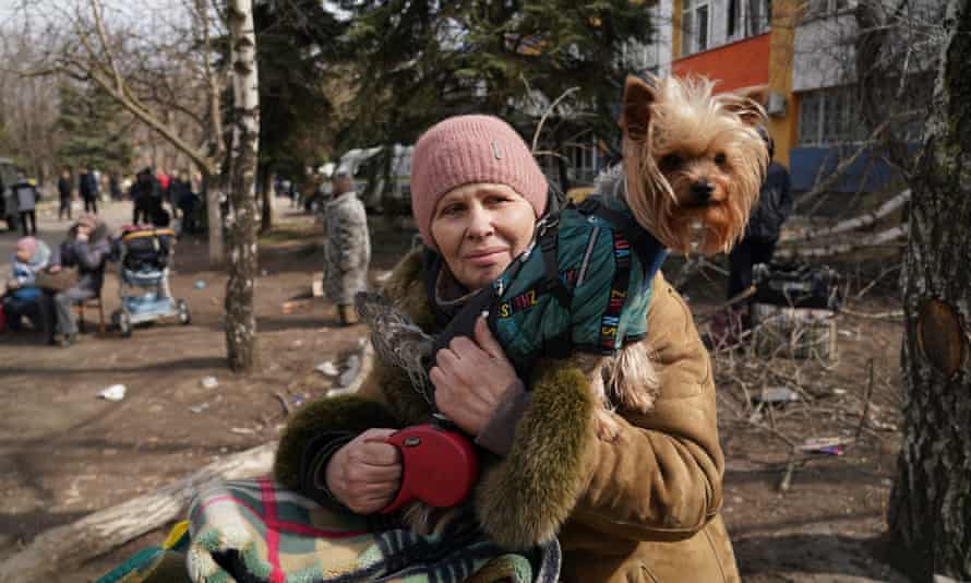 A woman holds her dog before waiting to flee the Ukrainian city of Mariupol.