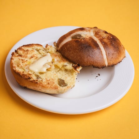 An Aldi Specially Selected rhubarb & custard hot cross bun, sliced, toasted and buttered, on a white plate