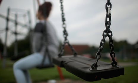 A teenage girl poses on a swing