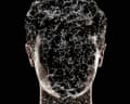 Connected particles covering dark, obscured face of man on black background