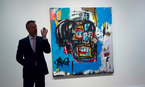 A Sotheby’s official stands next to Untitled, a 1982 painting by Jean-Michel Basquiat.