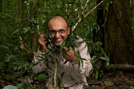Yadvinder Malhi smiles at the camera playing with a very flexible, leafy tree branch wrapped around his neck.