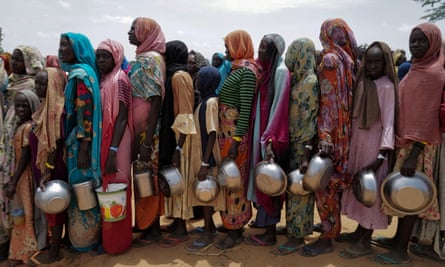 Sudanese women who fled the conflict in Geneina lining up to receive rice portions from Red Cross volunteers on the outskirts of Adré in July.