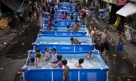 Children play in portbale pools, a project from the local government, to beat the heat in Manila 