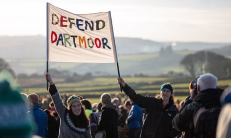 Protesters on Dartmoor hold a multicoloured banner that reads ‘Defend Dartmoor’
