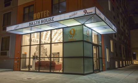 Exterior of BKLYN House Hotel, New York, at night, with its ground floor reception area illuminated.