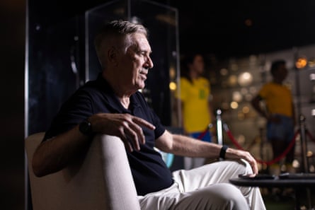 Carlo Ancelotti poses for a photo in a trophy room