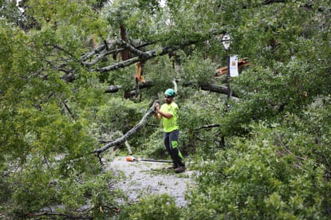 Workers remove trees from Meeting Street that were downed by Hurricane Ian in Charleston.