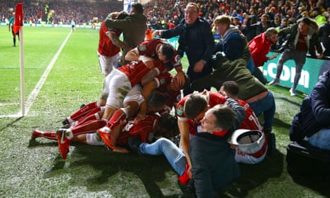 Korey Smith is mobbed by Bristol City players and fans after scoring their late winner against Manchester United.