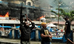 A Papuan police officer carries a riffle during a rally in which protesters torched Buruni in Fakfak on 21 August.