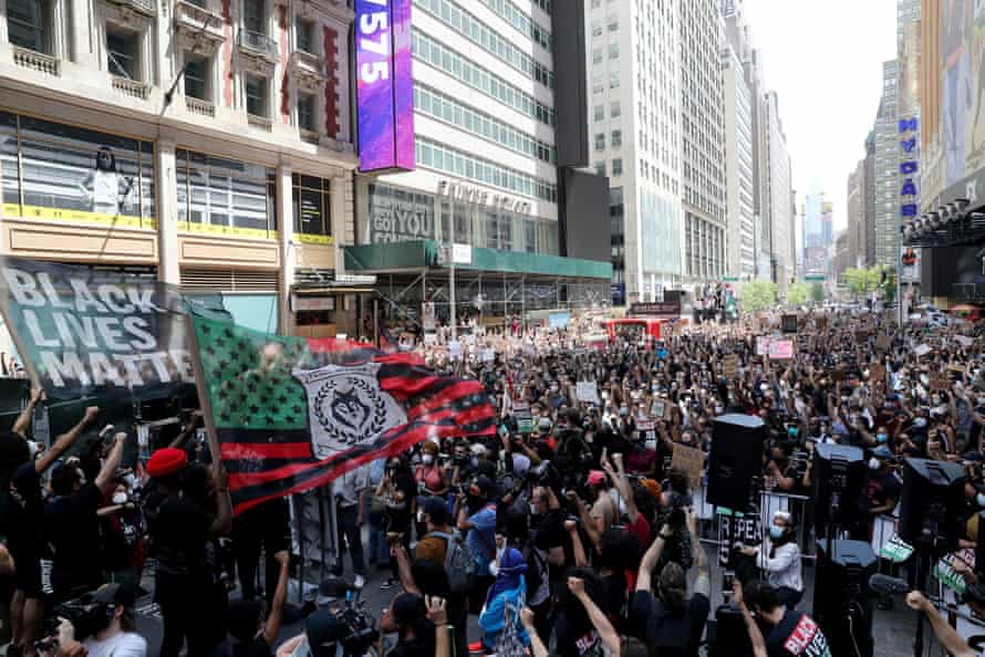 Demonstrators raise their fists at Times Square during a protest on Sunday.