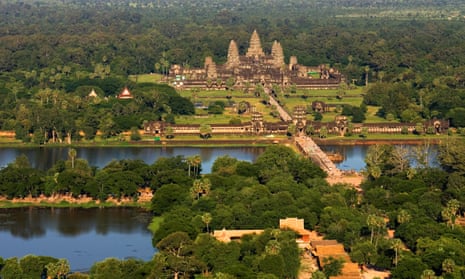 An aerial view of the Angkor Wat temple complex, surrounded by trees and with lakes in the foreground