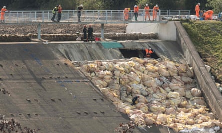Engineers and members of the emergency services inspect the damaged spillway of the Toddbrook reservoir dam