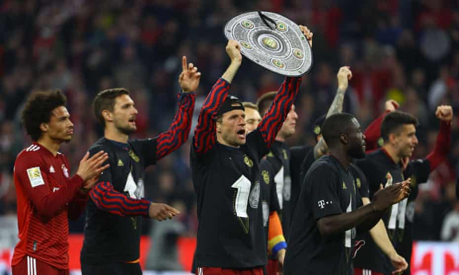 Bayern Munich's Thomas Müller holds aloft a replica Bundesliga trophy as the celebrations begin