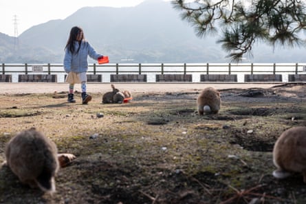 she is tipping food from a red container or package.