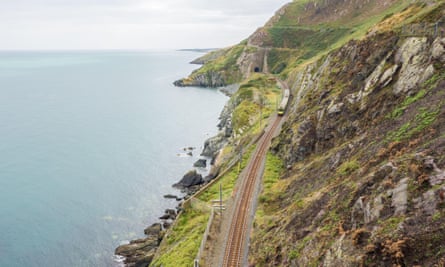 A train emerges from a tunnel on the coastal railway line on the cliffs between Bray and Greystones in County Wicklow.