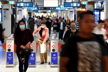Commuters in Sydney. In NSW masks are not compulsory but people have been told to consider wearing them in situations where they are unable to maintain a physical distance of 1.5m.