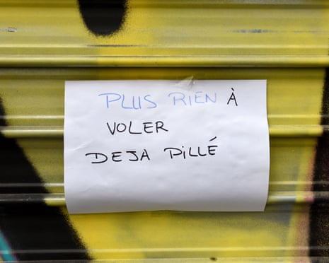 A handwritten sign reading "nothing left to steal, already looted" taped to a shutter