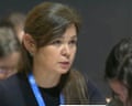 Daria Egereva with long brown hair wearing a blue lanyard looks to the side in an indoor setting