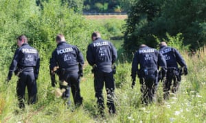 Police officers search for evidence near the crime scene in Würzburg, Germany