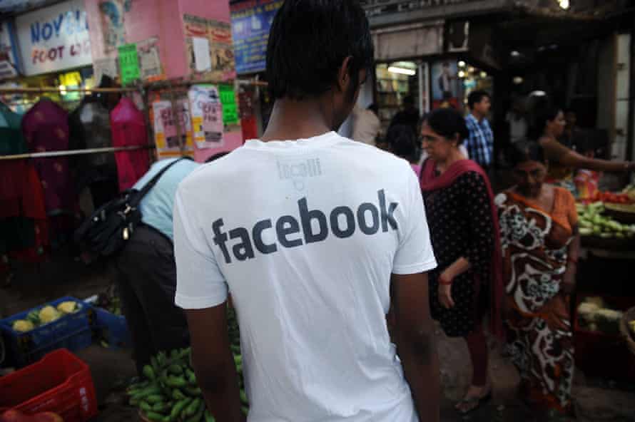 A young man Indian wearing a Facebook T-shirt at a market in Mumbai.