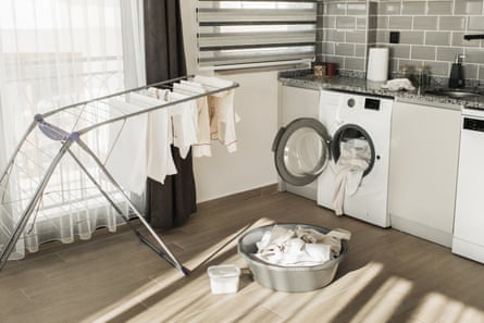 Modern kitchen with washing machine, dryer and laundry detergent. Laundry day. Routine home chores