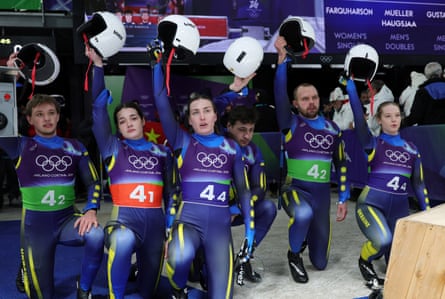 Yulianna Tunytska, Ihor Hoi,Nazarii Kachmar, Andriy Mandziy, Olena Stetskiv and Oleksandra Mokh of Ukraine raise their helmets in a tribute to Vladyslav Heraskevych