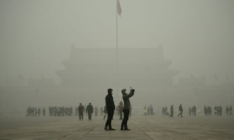 A visitor takes a photo in Tiananmen Square during heavy pollution in Beijing on December 1, 2015. Smog is being blamed for recent downturn in tourists.