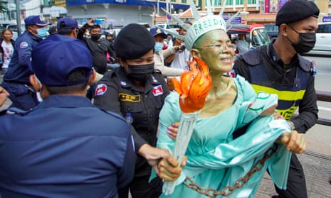 Theary Seng, dressed as Lady Liberty, is dragged  to jail  in Phnom Penh, Cambodia by police after being found guilty of treason.