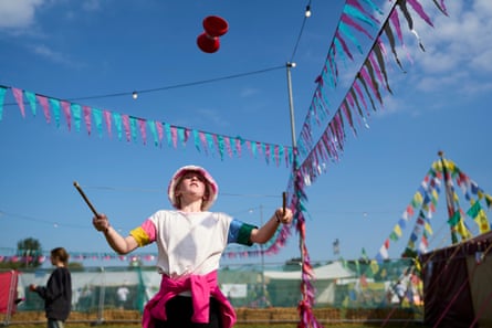 A girl playing with circus toys outside at a festival