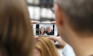 Apple CEO Tim Cook, right, takes a photo with an Apple employee