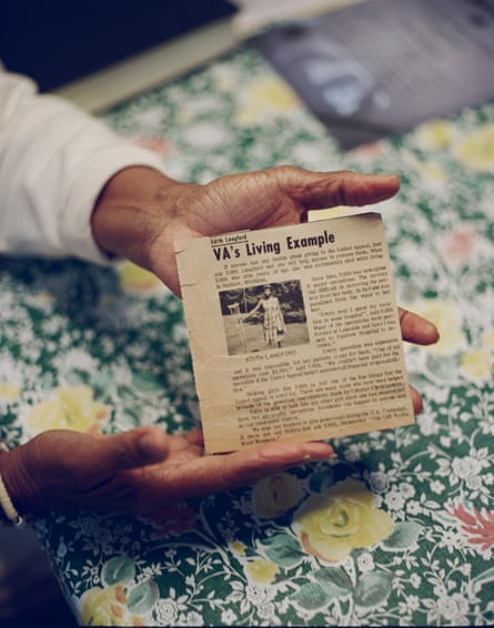 a woman holds an old newspaper cutting