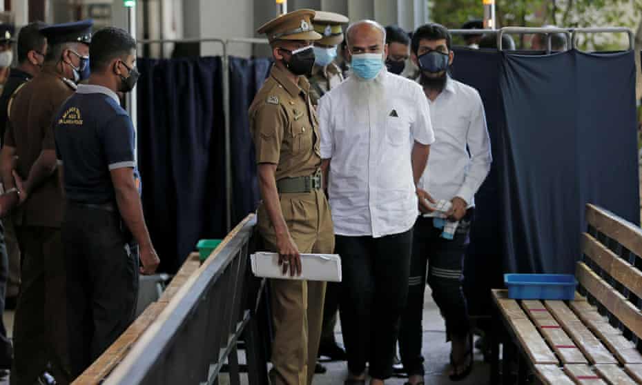 A key suspect YM Ibrahim (centre, white shirt), father of two of the suicide bombers, Inshaf and Ilham Ibrahim, arrives at the court in Colombo, Sri Lanka.