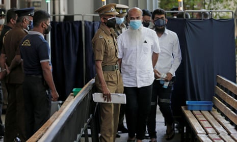 A key suspect YM Ibrahim (centre, white shirt), father of two of the suicide bombers, Inshaf and Ilham Ibrahim, arrives at the court in Colombo, Sri Lanka.