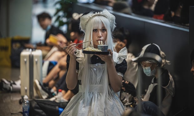 Seorang wanita muda bercosplay makan mie di China International Animation and Games Fair