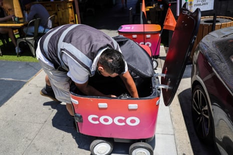 a person putting food in a delivery robots