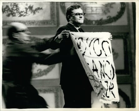 A man attempts to grab a placard displayed by protester