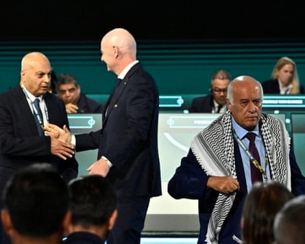 Jibril Rajoub, president of the Palestinian Football Association, walks off stage after refusing a photo with IFA vice-president Basim Sheikh Suliman (left) that was set up by Gianni Infantino (centre)