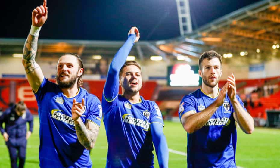 AFC Wimbledon’s Callum Kennedy, Harry Forrester and Jonathan Meades celebrate after the draw at Doncaster that secured their League One status