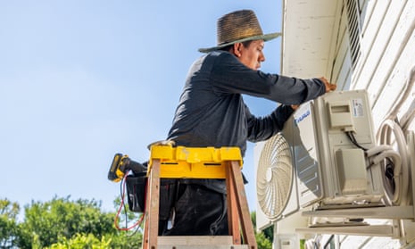 An AC technician repairs an air conditioning unit on in Austin, Texas.